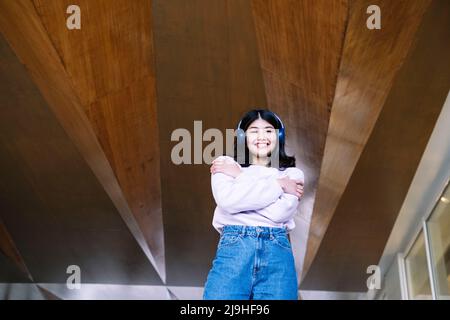 Die junge Frau umarmte sich unter der Holzdecke Stockfoto