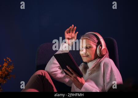 Ältere Frau, die zu Hause Wireless-Technologien verwendet Stockfoto