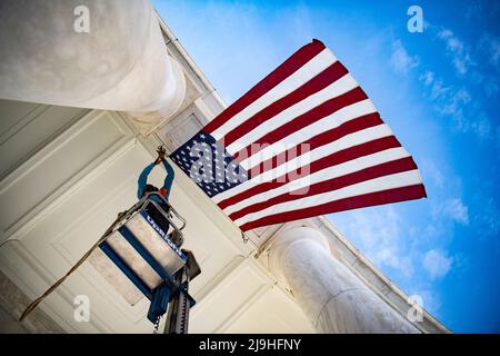 Arlington, Vereinigte Staaten Von Amerika. 23.. Mai 2022. Arlington, Vereinigte Staaten von Amerika. 23. Mai 2022. Mitarbeiter der Instandhaltung von Anlagen hängen amerikanische Flaggen im Arlington National Cemetery Memorial Amphitheater, um sich auf die jährliche Gedenkveranstaltung zum Gedenken an die Kriegstoten der Nationen am 23. Mai 2022 in Arlington, Virginia, USA, vorzubereiten. Kredit: Elizabeth Fraser/U.S. Army/Alamy Live News Stockfoto