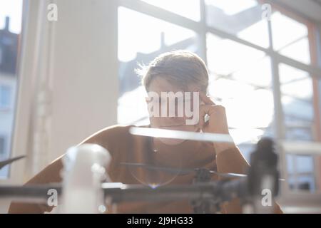 Nachdenklicher Geschäftsmann, der im Büro Drohne ansieht Stockfoto