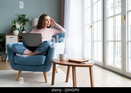 Besinnlicher Freiberufler mit Laptop im Wohnzimmer Stockfoto