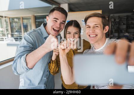 Glückliche Geschäftsleute, die im Büro ein Selfie machen Stockfoto