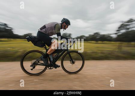 Verschwommene Bewegung des Radfahrers auf unbefestigten Straßen Stockfoto