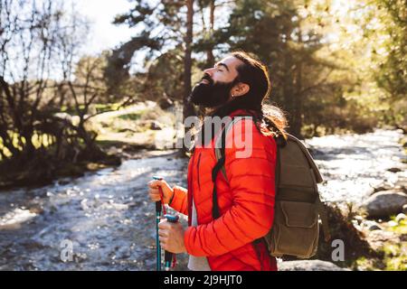 Bärtiger Mann mit geschlossenen Augen im Wald stehend Stockfoto