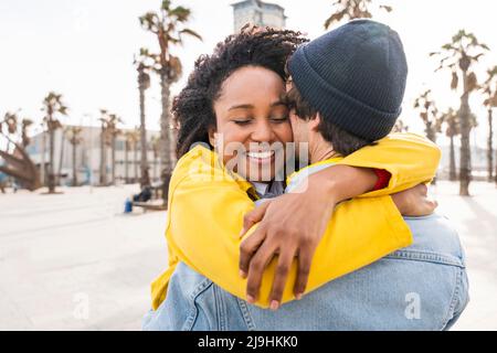 Lächelnde Afro-Frau umarmte den Mann Stockfoto