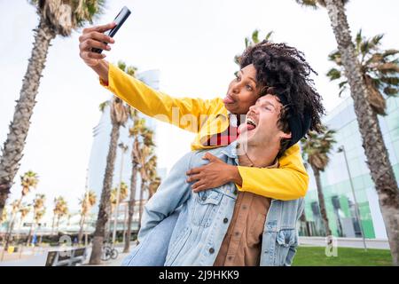 Paar ragt aus Zungen und nimmt Selfie über das Smartphone Stockfoto