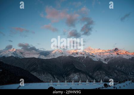 Weiße Pagoden des feilai-Tempels mit meili-Schneeberg bei Sonnenaufgang im Hintergrund in der chinesischen provinz yunnan Stockfoto