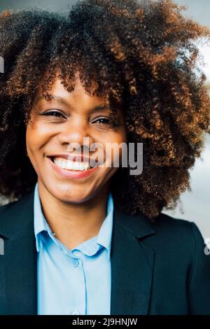 Fröhliche Afro-Geschäftsfrau in Anzug Stockfoto