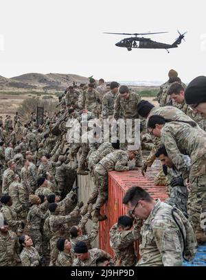 Fort Carson, Usa. 23.. Mai 2022. Soldaten der US-Armee, die der Infanterie-Division 4. zugewiesen wurden, helfen beim Utah Beach Challenge Event am 23. Mai 2022 in Fort Carson, Colorado, einander über eine schlammige Containerwand zu stoßen. Die Veranstaltung während der Ivy Week erfordert Teams von Soldaten, einen 300-Pfund-Reifen über einen schlammigen Hindernisparcours zu tragen. Kredit: SSGT. Matthew Lumagui/USA Army/Alamy Live News Stockfoto