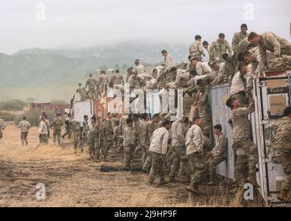 Fort Carson, Usa. 23.. Mai 2022. Soldaten der US-Armee, die der Infanterie-Division 4. zugewiesen wurden, helfen beim Utah Beach Challenge Event am 23. Mai 2022 in Fort Carson, Colorado, einander über eine schlammige Containerwand zu stoßen. Die Veranstaltung während der Ivy Week erfordert Teams von Soldaten, einen 300-Pfund-Reifen über einen schlammigen Hindernisparcours zu tragen. Kredit: SSGT. Matthew Lumagui/USA Army/Alamy Live News Stockfoto