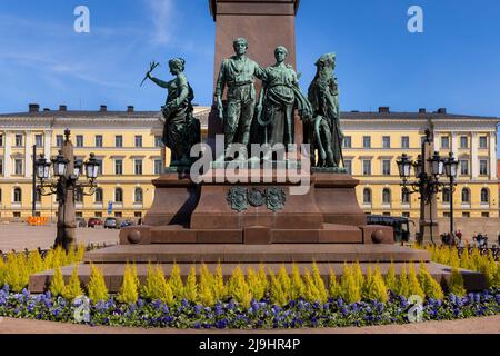 Kleine Figuren unter der Statue von Alexander II. Von Russland in Helsinki, Finnland Stockfoto