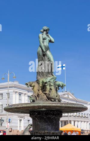 Havis Amanda -Statue, die im Zentrum von Helsinki vor einer finnischen Flagge steht Stockfoto