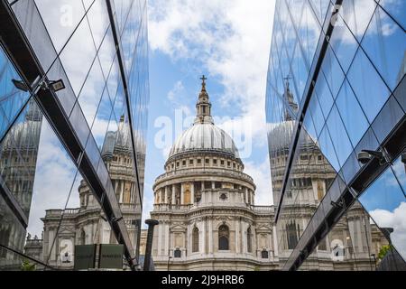 St. Pauls Cathedral im Mai 2022 unter einem hellen Himmel zwischen zwei modernen Fassaden im Herzen Londons abgebildet. Stockfoto