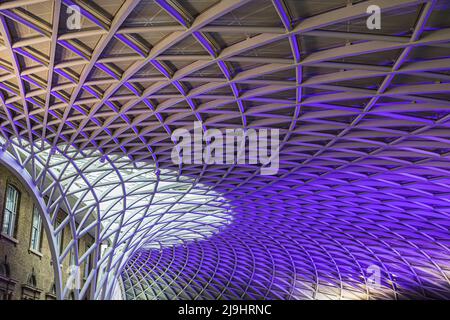 Die abstrakte Decke des Kings Cross-Bahnhofs wurde in London im Mai 2022 in violettem Licht beleuchtet. Stockfoto