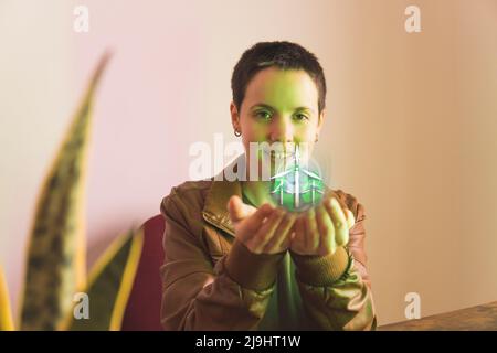 Lächelnder Freiberufler, der die Hologrammgestaltung von Windenergieanlagen im Büro analysiert Stockfoto