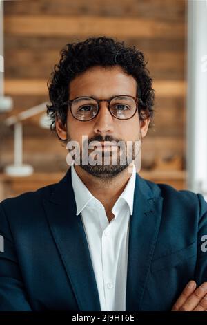 Geschäftsmann mit Brille, der vor der Wand steht Stockfoto