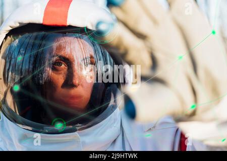 Astronaut mit einer transparenten High-Tech-Grafikschnittstelle Stockfoto