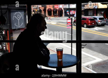 Ein Mann genießt ein Bier im Vesuvio Cafe, einer der Wahrzeichen der amerikanischen Bar im North Beach-Viertel von San Francisco, Kalifornien. Stockfoto