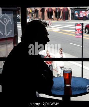 Ein Mann genießt ein Bier im Vesuvio Cafe, einer der Wahrzeichen der amerikanischen Bar im North Beach-Viertel von San Francisco, Kalifornien. Stockfoto