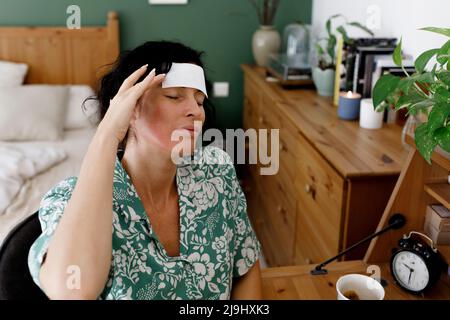 Geschäftsfrau mit geschlossenen Augen und Kopfschmerzen zu Hause Stockfoto