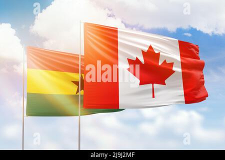 Sonniger blauer Himmel und Flaggen von kanada und ghana Stockfoto