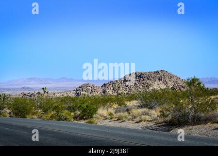 Joshua Tree National Park, in der Mojave-Wüste, mit Blick auf die Autobahn auf das sich ausdehnende Coachcella Valley und Felsformationen mit Wüstenlandschaft, CA Stockfoto