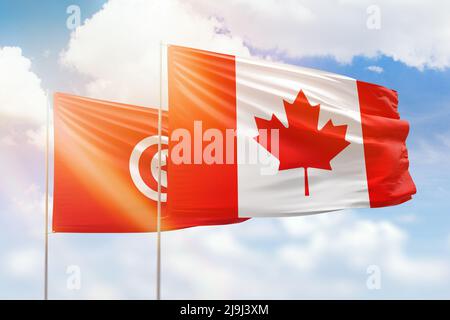 Sonniger blauer Himmel und Flaggen von kanada und tunesien Stockfoto