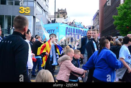 Manchester, Großbritannien, 23.. Mai 2022. Unterstützer eilen, um den oben offenen Bussen nach Deansgate zu folgen. Der Manchester City Football Club veranstaltet eine Siegesparade, um den Titelgewinn des Clubs in der Premier League zu feiern, nachdem er am 22.. Mai im Etihad Stadium gegen Aston Villa gewonnen hatte. Die Parade der offenen Busse führte durch das Zentrum von Manchester, England, Großbritannien. Der Club sagte: „Der Club wird seinen Sieg mit Fans mit einer Open-Top-Busparade im Stadtzentrum von Manchester am Montag, dem 23.. Mai feiern, die mit einer Bühnenshow im Deansgate (Beetham Tower) endet.“ Quelle: Terry Waller/Alamy Live News Stockfoto