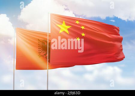 Sonniger blauer Himmel und Flaggen von china und albanien Stockfoto