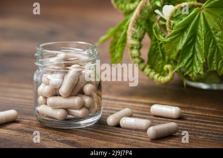 Kräuterpillen, Glas von natürlichen Tabletten. Heilkräuter auf dem Hintergrund. Stockfoto