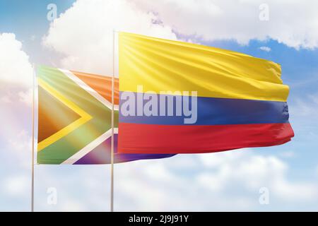 Sonniger blauer Himmel und Flaggen von kolumbien und Südafrika Stockfoto