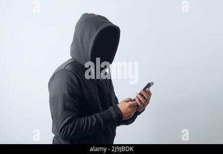 Geheimnisvoller Mann mit Hoodie und Telefon Stockfoto