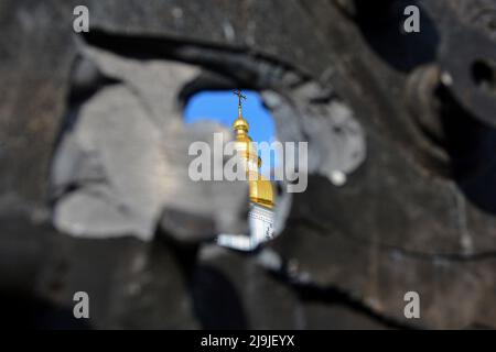 Kiew, Ukraine. 23.. Mai 2022. Blick auf den Glockenturm der St. Michaels Golden-Dome-Kathedrale durch ein Loch in der Rüstung eines russischen Panzers, der auf dem Mykhailivska-Platz ausgestellt wurde. Russland marschierte am 24. Februar 2022 in die Ukraine ein und löste damit den größten militärischen Angriff in Europa seit dem Zweiten Weltkrieg aus Kredit: SOPA Images Limited/Alamy Live Nachrichten Stockfoto