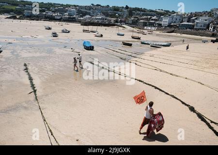 Ein Aktivist des Extinction Rebellion spaziert am Strand entlang während des Aktionstages „All Hands on Deck“ am letzten Tag des Gipfeltreffens G7 in St. Ives, Cornwall. Das Thema bezieht sich auf die dritte Forderung von Extinction Rebellion nach einer Bürgerversammlung für ökologische und Klimagerechtigkeit, um über die zerbrochene parlamentarische Demokratie hinauszugehen und die Macht in die Hände der Bürger zu legen. Stockfoto