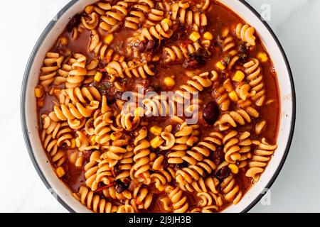 Vegane Spiral-Pasta mit würziger Tomatensauce mit Bohnen und Mais, gesunde pflanzliche Speiserezepte Stockfoto