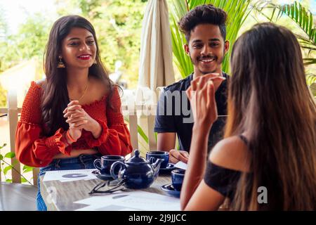 Multikulturelle Gruppe von Menschen diskutieren mit dem Laptop im Sommer Café Surfen online Freiberufler freiberuflich Stockfoto