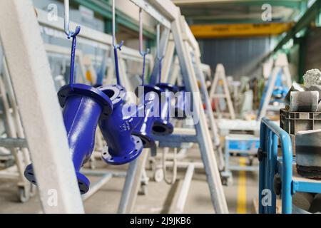 Kehl, Deutschland. 28. April 2022. Frisch lackierte Rohrleitungen hängen in einer Halle der Herrenknecht AG Rebuild Services in Kehl. Hier zerlegt der Tunnelbohrmaschinenhersteller alte Maschinen in ihre Einzelteile, konditioniert sie und montiert sie wieder. (To dpa 'alt in neu verwandeln - wo Tunnelbohrmaschinen auseinandergerissen werden') Quelle: Benedikt Spether/dpa/Alamy Live News Stockfoto