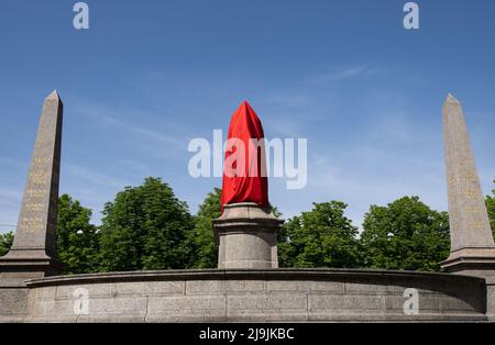 Stuttgart, Deutschland. 23.. Mai 2022. Ein Denkmal für Kaiser Wilhelm I. auf dem Stuttgarter Karlsplatz ist mit einem roten Tuch bedeckt. Neben dem Kulturbüro hatten mehrere Organisatoren des bevorstehenden Katholikentages das Künstlerkollektiv Reminect beauftragt, das Denkmal künstlerisch zu kontextualisieren. Der Grund: Wilhelm I., als Kaiser der Gründung des Deutschen Reiches, ist nach Angaben der Organisatoren mit dem Beginn des Nationalismus und der später einsetzenden Kolonisierung des Deutschen Reiches verbunden. Quelle: Marijan Murat/dpa/Alamy Live News Stockfoto