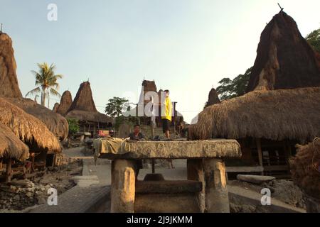 Ein Kind, das auf einem megalithischen Dolmen im traditionellen Dorf Waitabar, an der Grenze zum Dorf Tarung in Soba Wawi, Loli, Waikabubak, West Sumba, Ost Nusa Tenggara, Indonesien. Stockfoto