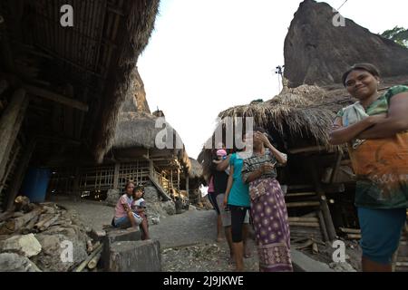 Porträt einer Gruppe von Frauen, die auf dem Weg zwischen traditionellen Häusern im traditionellen Dorf Tarung in Soba Wawi, Loli, Waikabubak, West Sumba, East Nusa Tenggara, Indonesien. Stockfoto