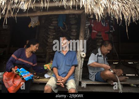 Portrait einer Gruppe von Dorfbewohnern, die auf der Veranda eines Hauses im traditionellen Dorf Tarung in Soba Wawi, Loli, Waikabubak, West Sumba, Ost Nusa Tenggara sitzen, Indonesien. Stockfoto