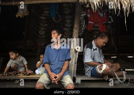 Portrait einer Gruppe von Dorfbewohnern, die auf der Veranda eines Hauses im traditionellen Dorf Tarung in Soba Wawi, Loli, Waikabubak, West Sumba, Ost Nusa Tenggara sitzen, Indonesien. Stockfoto