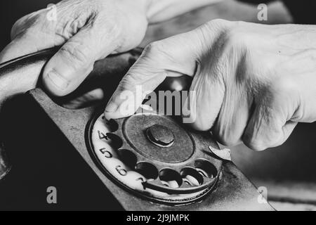 Altes Retro-Telefon schwarz und die Hand der Frau Nahaufnahme, Anruf am Telefon, Technologie Stockfoto