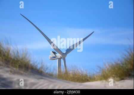 Hvide Sande, Dänemark. 21. April 2022. Eine Windkraftanlage mit der Aufschrift „Vestas“ steht vor einem blauen Himmel zwischen Sanddünen in der Nähe des Dorfes Hvide Sande. Quelle: Jonas Walzberg/dpa/Alamy Live News Stockfoto