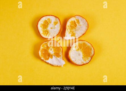 Mehrere Stücke von orangefarbenem Pell auf gelbem Hintergrund Stockfoto