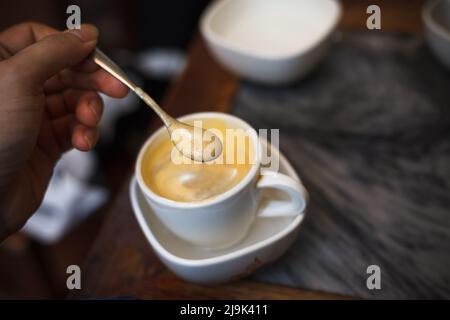 Draufsicht eine Tasse Giang Eierkaffee auf Holz Hintergrund. Vietnamesischer Kaffee in Ha Noi, Vietnam. Eier werden mit Kaffee, Heißgetränk oder mit Eis geschlagen Stockfoto