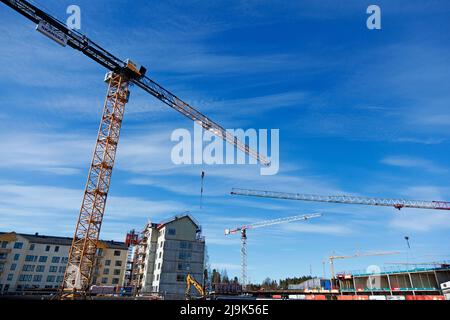 Umea, Norrland Schweden - 13. Mai 2022: Vier Krane während des Wohnungsbaus auf Teg Stockfoto