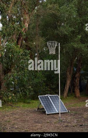 Sonnenkollektoren unter dem Basketballkorb unter Bäumen Stockfoto