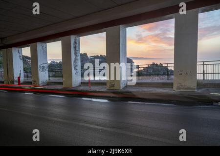 Straßentunnel über dem Meer bei Sonnenaufgang Stockfoto