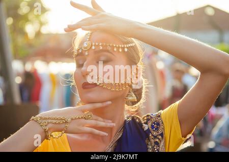 Porträt indisch schöne kaukasische Frau in traditionellen blauen Kleid.hindu-Modell mit goldenen Kundan Schmuck-Set bindi Ohrringe und Nasenring Piercing Stockfoto